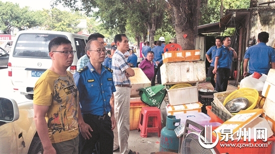 城管对占道经营的鱼市进行纠正,劝导他们入市经营.